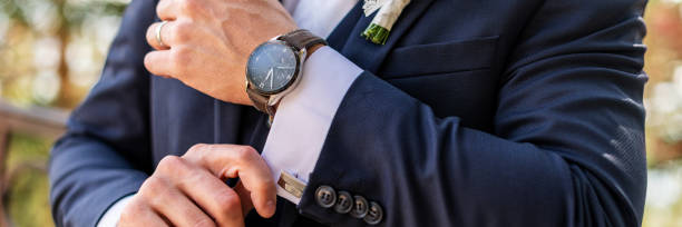 istock Groom fixing his cufflinks. Handsome groom dressed in dark blue formal suit getting ready for wedding. Elegant groom wedding fashion. 1345996183