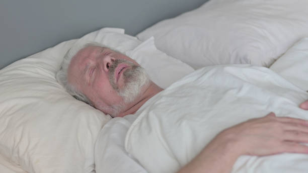 istock Peaceful Senior Old Man Sleeping in Bed 1345996651
