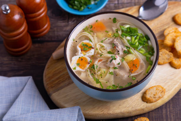 Soup with chicken, noodles, potatoes, quail egg and carrots. Seasoned with onions and parsley.