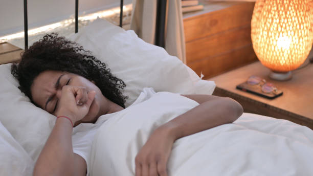 istock Young African Woman with Cough Laying in Bed, Flu 1345997497