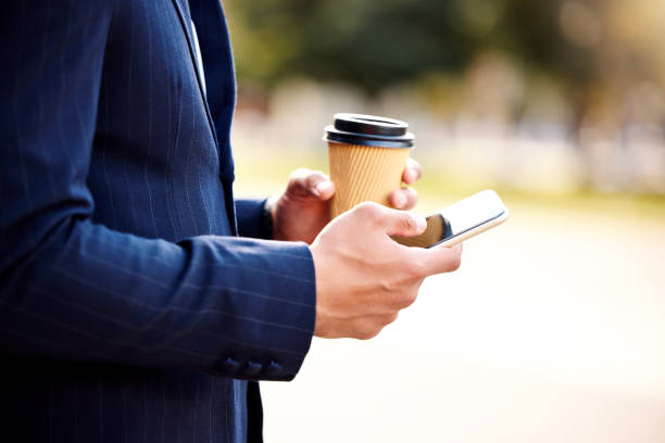 istock Shot of a businessman using his smartphone while drinking coffee 1345997554