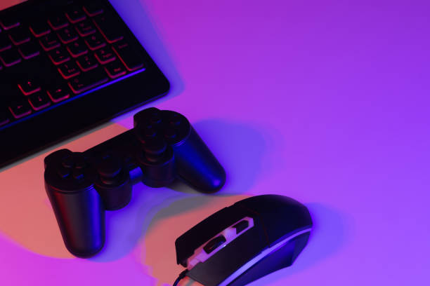 istock Accessory gaming keyboard joystick mouse headphone with blank space. Gadget for gamer playing video game online in the neon light darkroom. 1345997817