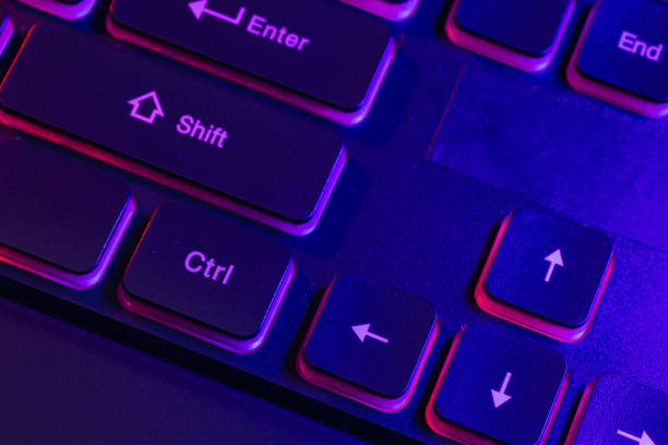 istock Accessory gaming keyboard with blank space background. Gadget for gamer playing video game online in the neon light darkroom. 1345997861