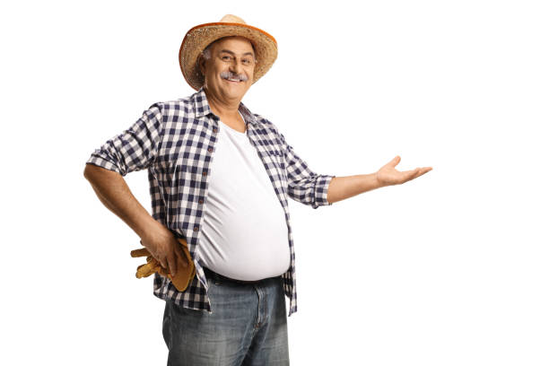 istock Smiling mature farmer showing with hand 1345998220