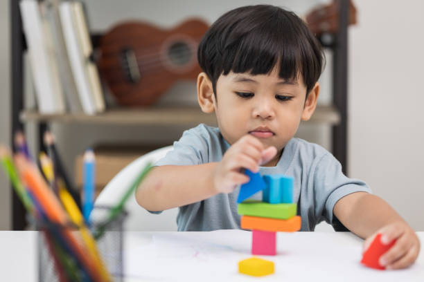 istock Asian little boy education from home. Developing children's learning before entering kindergarten Practice the skills of playing with wooden toys in living room. 1345999228