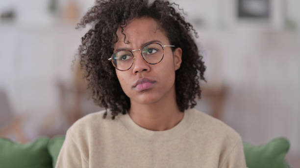 istock Young African Woman Looking at Camera at Home 1345999230