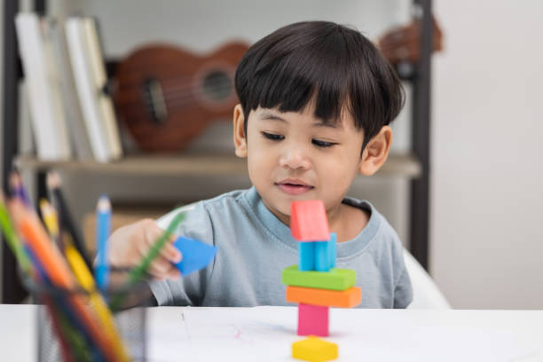 istock Asian little boy education from home. Developing children's learning before entering kindergarten Practice the skills of playing with wooden toys in living room. 1345999242