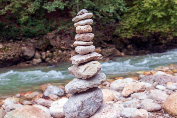 istock Stone pyramid near a fast mountain river. Harmony and balance concept. 1345999378