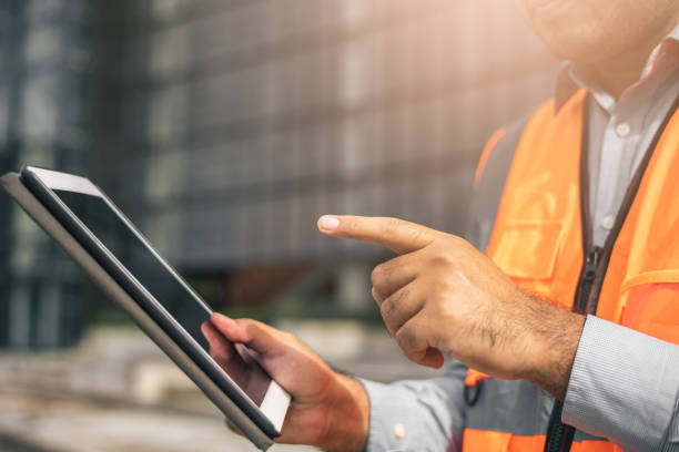 istock Close up worker indian civil engineer using tablet planning the project build the modern construction reading the blueprint. Asian Architecture or engineer working in the building construction sit 1345999667