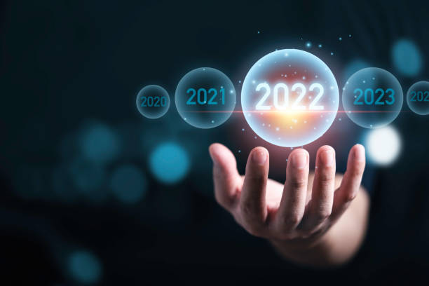 hombre de mano sosteniendo el año virtual 2022 con bokeh azul para la preparación feliz navidad y feliz año nuevo concepto. - touch screen futuristic technology forecasting fotografías e imágenes de stock