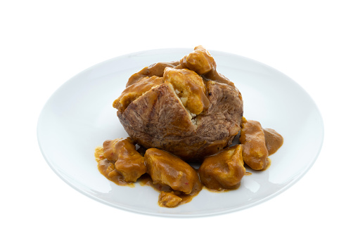 Baked jacket potato filled with chicken curry - white background