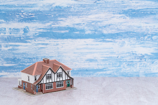 A 3d rendering of hands holding paper house, family home, homeless shelter and real estate