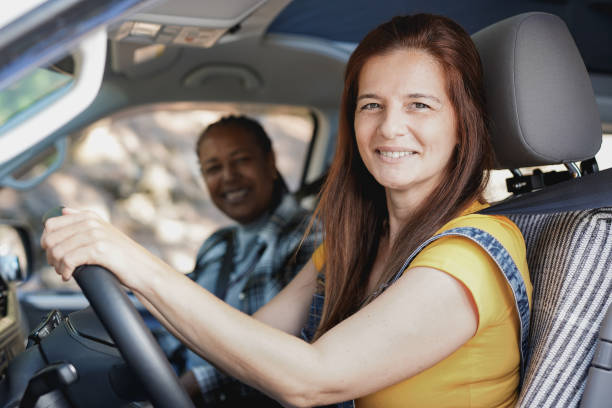 istock Multiracial mature women on a road trip with mini van camper while smiling on camera 1346004017