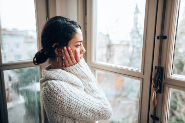 istock pensive woman looking at the window 1346005996