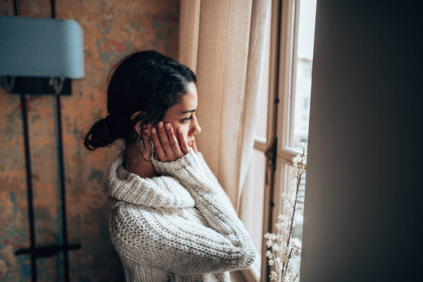 istock pensive woman looking at the window 1346006018