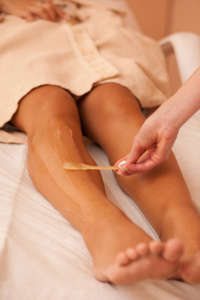 beautician waxing female legs in spa center - beautician beauty treatment smooth human leg imagens e fotografias de stock