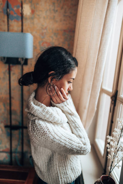 istock pensive woman looking at the window 1346006460