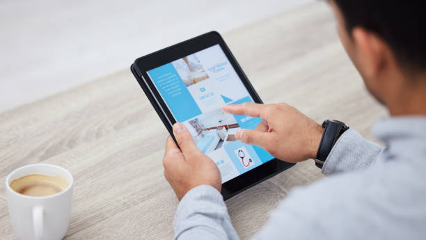 istock Shot of a businessman drinking coffee while using his digital tablet 1346007478