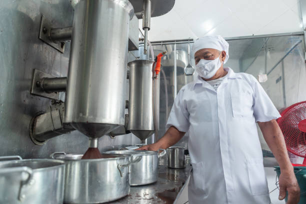 istock Worker operating an industrial mixer for extraction of acai pulp 1346007920