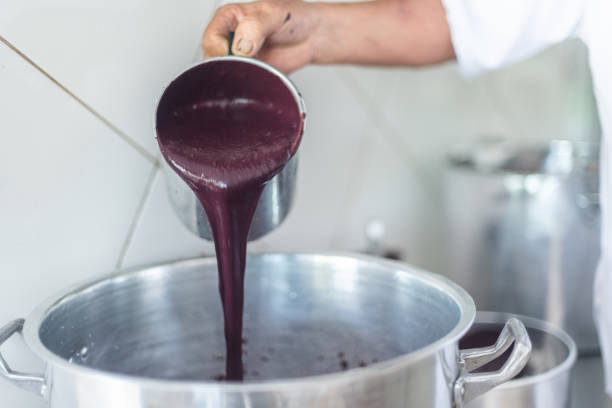 istock Worker pouring just extracted fresh acai pulp into a pan 1346008373
