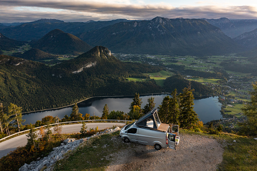 Drone Point of View Single Camper Van, Car With Roof Top Tent, Praked High up in the Mountains Above Mountain Road With View to Lake, Valley and Panorama of Alps