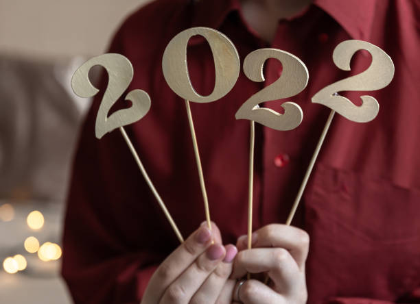 istock Christmas background with numbers 2022 in female hands. 1346009319