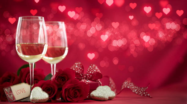 istock Valentine's Day Red Roses and White Wine on a Defocused Lights Background 1346009850