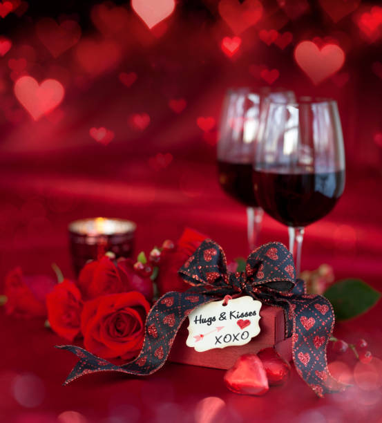 istock Valentine's Day Red Roses and Red Wine with a Gift on a Defocused Lights Background 1346009925