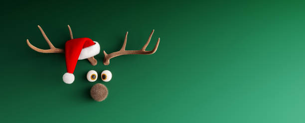 reno con sombrero de papá noel en maqueta verde fondo navideño - reindeer fotografías e imágenes de stock