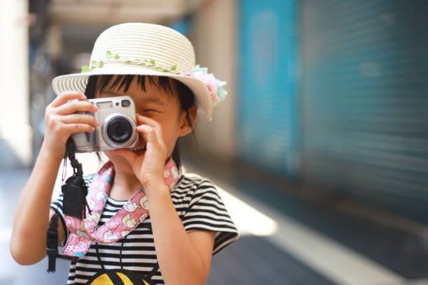 istock a Asian girl take photos with a digital camera. 1346012641