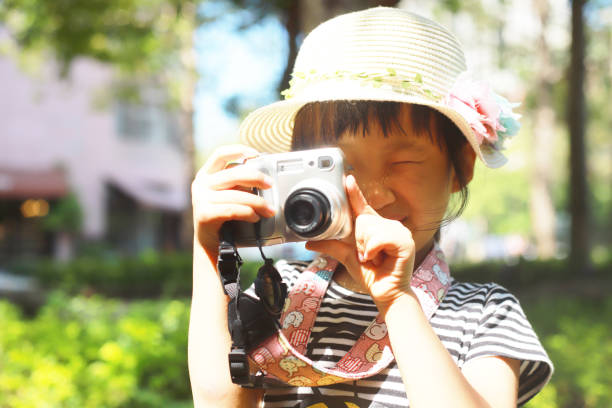 istock a Asian girl take photos with a digital camera. 1346013157