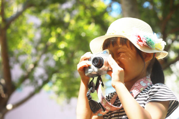 istock a Asian girl take photos with a digital camera. 1346013207