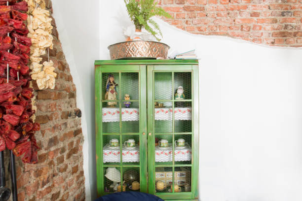 A rustic wooden bench sits quietly outside a mosaic-tiled wall beneath an open wooden window. The dusky light and retro feel evoke a nostalgic atmosphere, like a quiet corner of an old café.