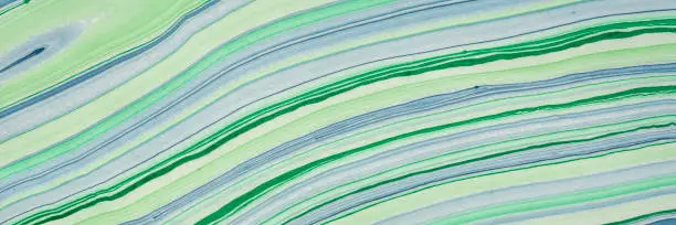 background of handmade Thai marbled mulberry paper in green and blue with flowing pattern, panoramic web banner