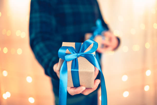 istock Hands holding gift box, present on the table and light of bokeh background. Valentine's Day, Christmas, Birth day, New year and Anniversary concept. 1346017497