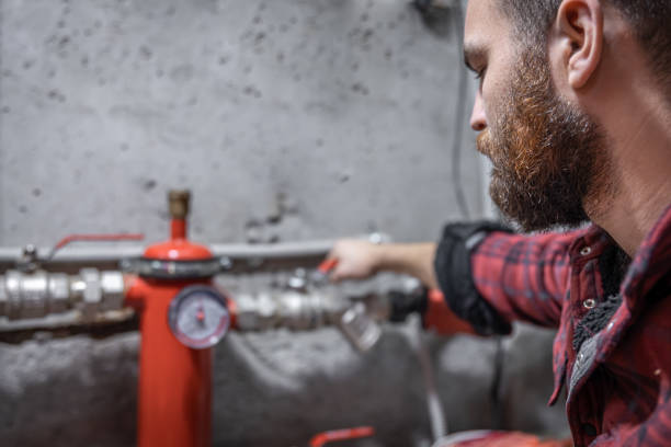 l’homme regarde le robinet, les tuyaux, la vanne, le pressomètre. - water meter photos et images de collection