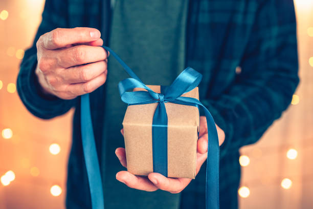 istock Hands holding gift box, present on the table and light of bokeh background. Valentine's Day, Christmas, Birth day, New year and Anniversary concept. 1346018283