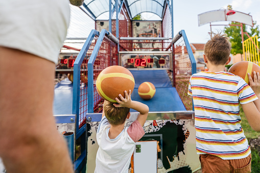 Photo of little boys and their father shooting hoops at the traveling fair