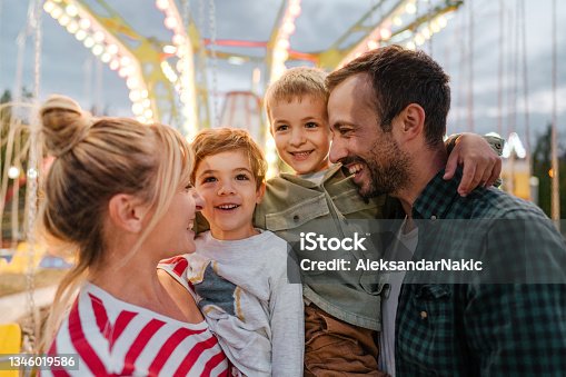istock Happy family at the amusement park 1346019586