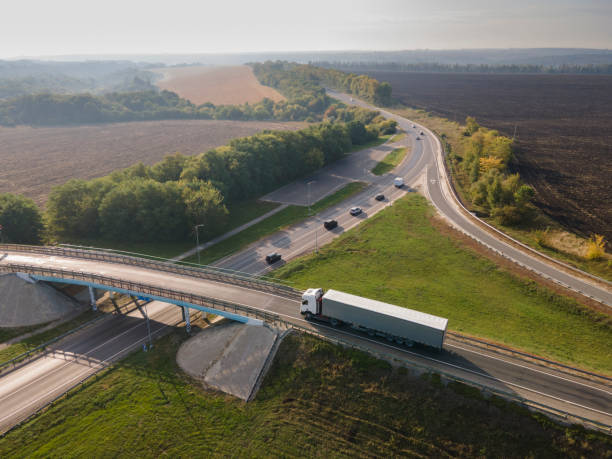 istock Truck with Cargo Semi Trailer Moving on Road in Direction. Highway intersection junction. Aerial Top View 1346022503