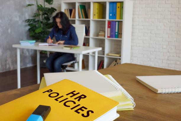 HR policies guide book on desk near employee. stock photo