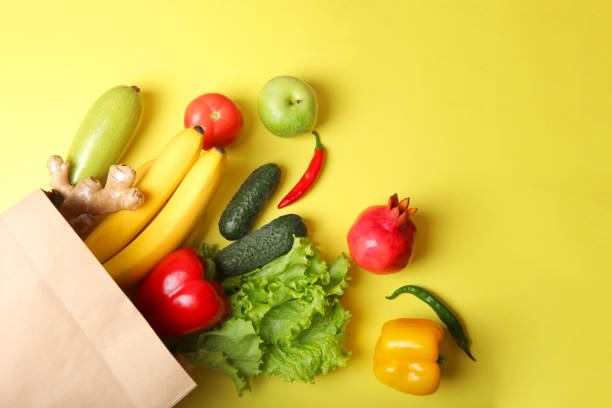 istock Products in a paper bag on a colored background with place for text top view. 1346022646
