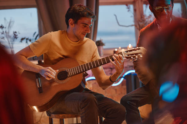 istock Man playing guitar for his friends 1346027819