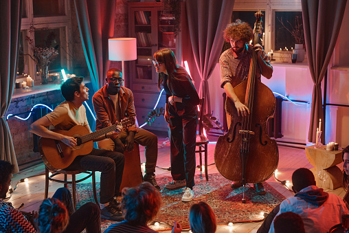 Group of people playing musical instruments for people in the night club