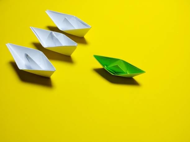 istock white and green paper boat yellow background 1346028339