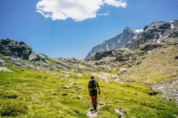 Hiker doing trekking along the high mountain path