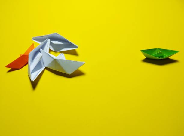 istock falling green white paper boat The yellow background 1346029276
