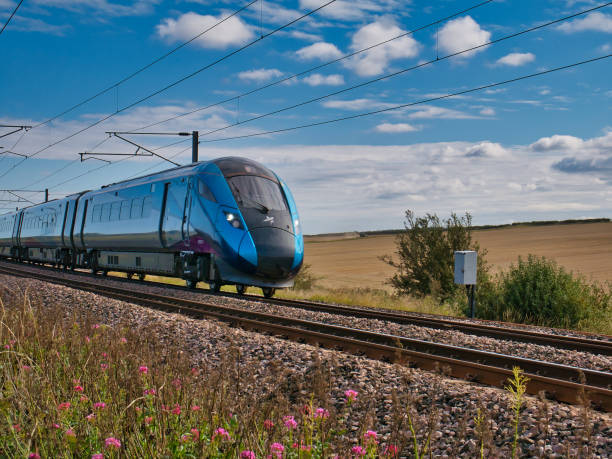 un treno transpennine express che viaggia a velocità nel northumberland, nel regno unito - preso in una giornata di sole con nuvole bianche. - british rail foto e immagini stock