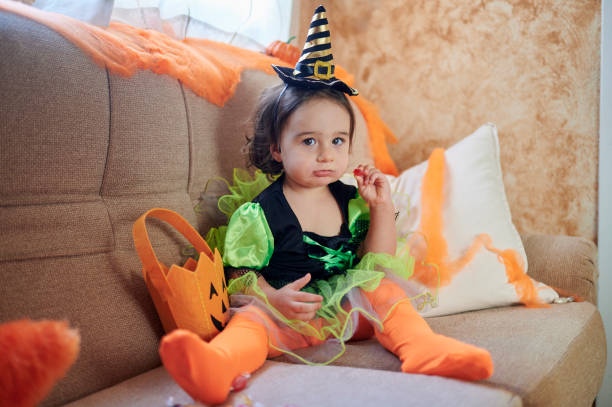 istock Baby dressed as a witch with Halloween candy 1346029559