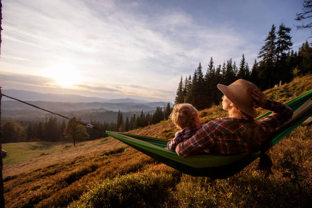 istock Boy with mom resting in a hammock in the mountains at sunset 1346029802